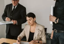 Jak zabezpieczyć firmę przed kradzieżą własności intelektualnej Zespół menedżerów analizuje wydrukowane wykresy i podpisuje dokumenty.