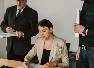 Jak zabezpieczyć firmę przed kradzieżą własności intelektualnej Zespół menedżerów analizuje wydrukowane wykresy i podpisuje dokumenty.