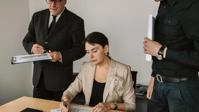 spotkanie-ochrona-wlasnosci-intelektualnej Zespół menedżerów analizuje wydrukowane wykresy i podpisuje dokumenty.